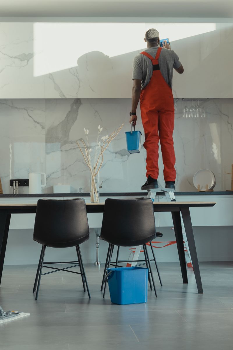 Professional cleaning team in red uniforms mopping and polishing a modern home